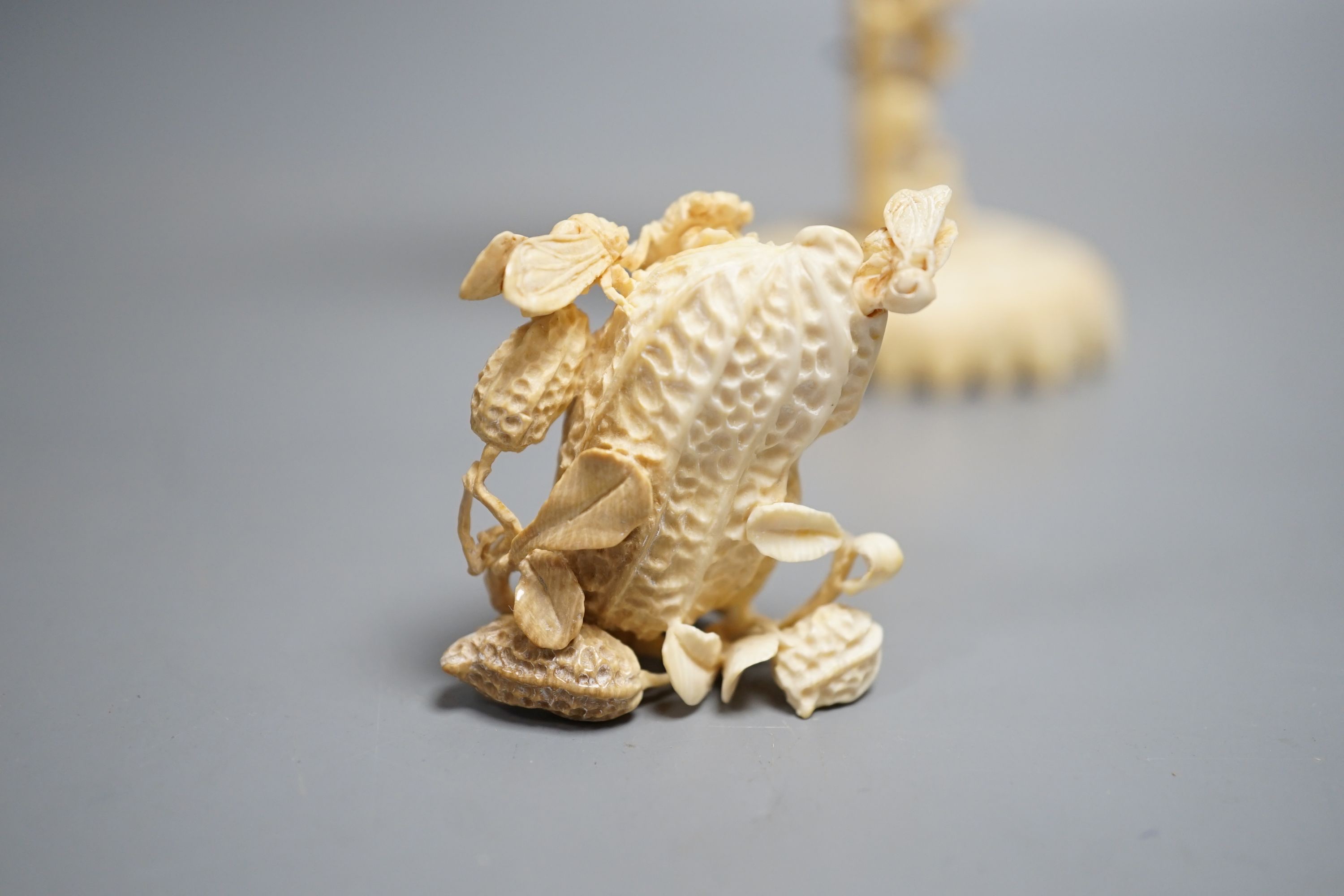 A Chinese ivory concentric puzzle ball and stand, two Chinese ivory snuff bottles and stoppers, modelled as a leaping carp and as cicadas on a nut, early 20th century